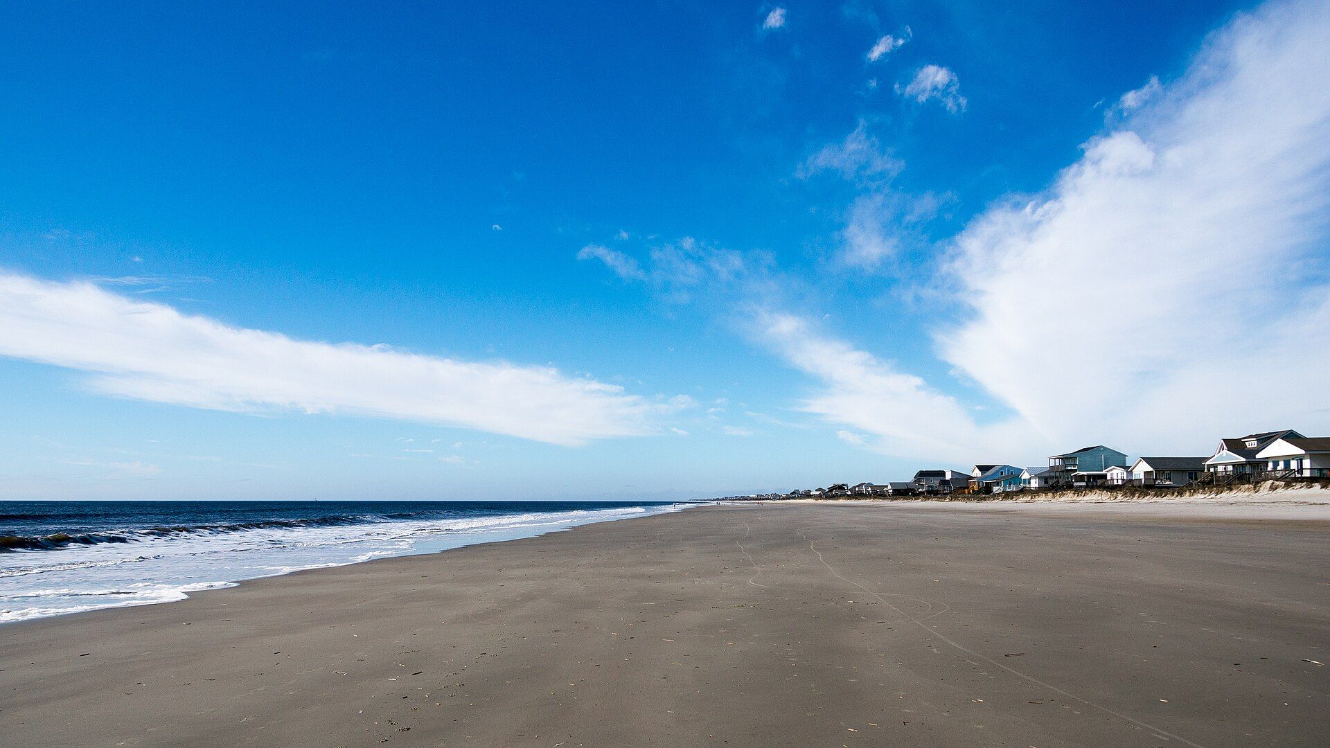 Wide empty beach on Oak Island under a blue sky