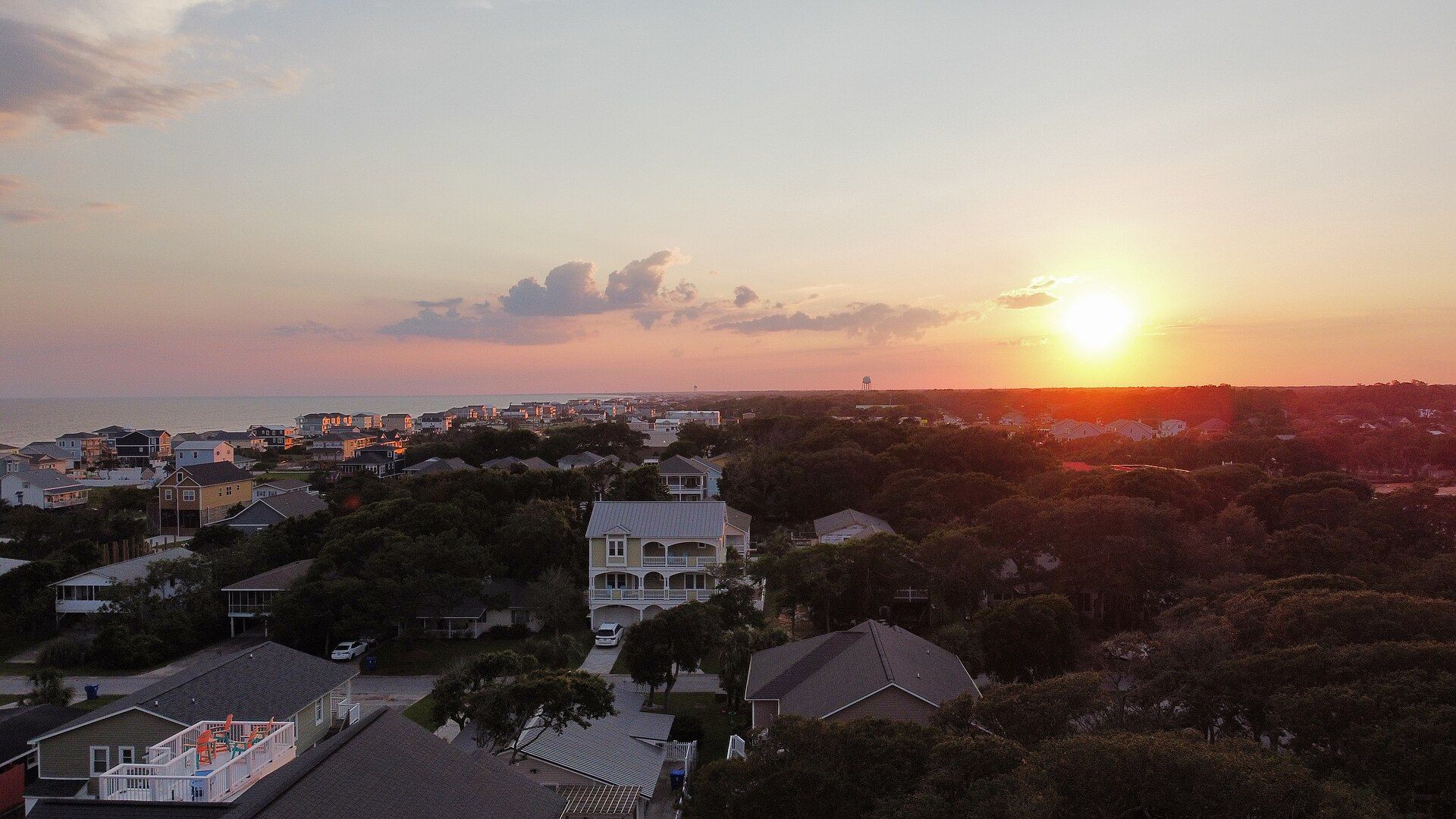 Sunset over Oak Island rooftops and maritime forest